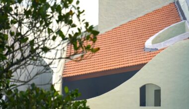 curved cutouts sculpt fluid voids within gabled residence in vietnam