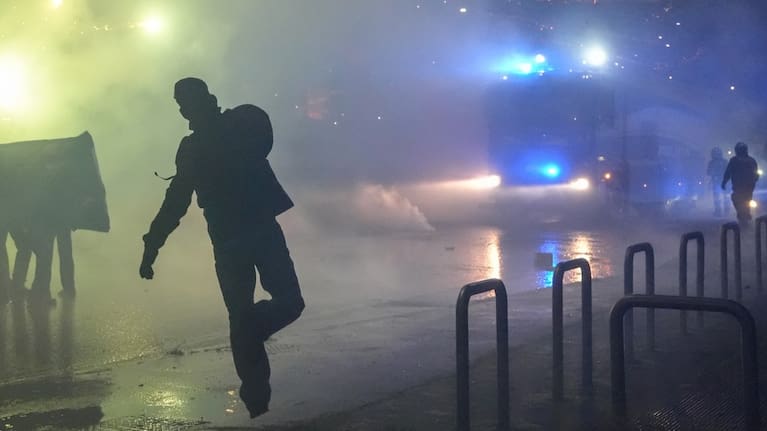 Demonstrators face riot police during a protest against the Milan-Cortina 2026 Olympics, in Milan, Italy.