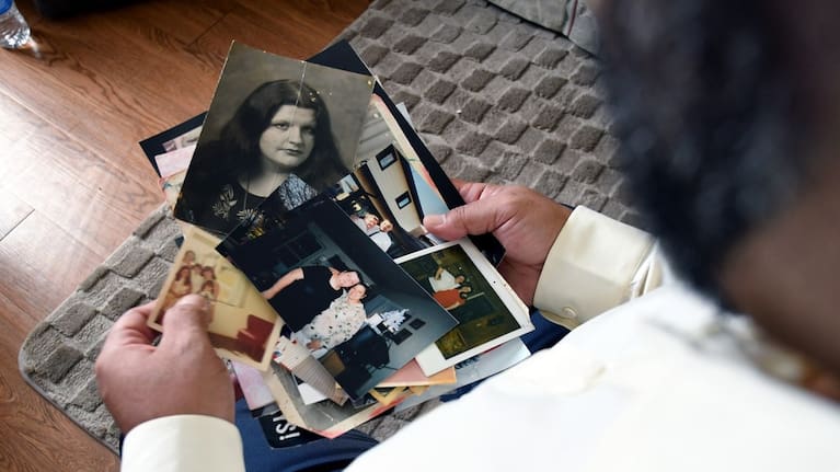 Derrick Johnson holds photographs of his mother, whose body was one of 189 left to decay in the Return to Nature Funeral Home.