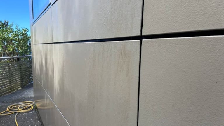 Despite three attempts with the hose, a brown smear remains on Chris' house.