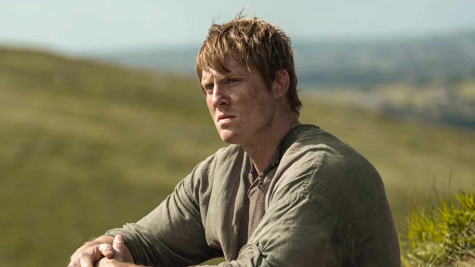 Dunk sitting in a field in A Knight of the Seven Kingdoms