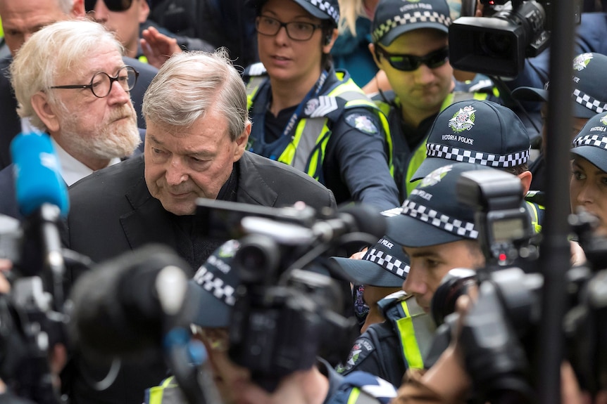 A man walks among police. 