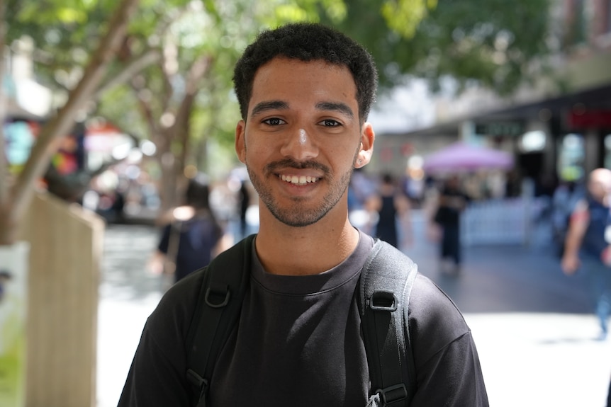 A young man with brown hair and black T-shirt.