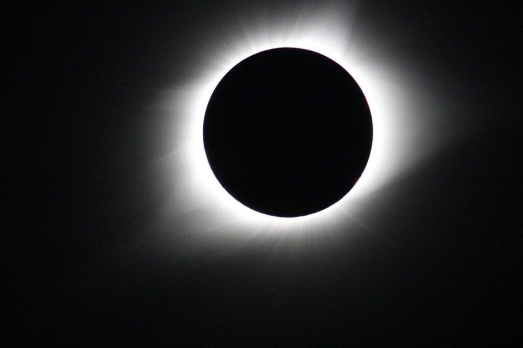 Eclipse solar total con corona brillante y oscuridad central.