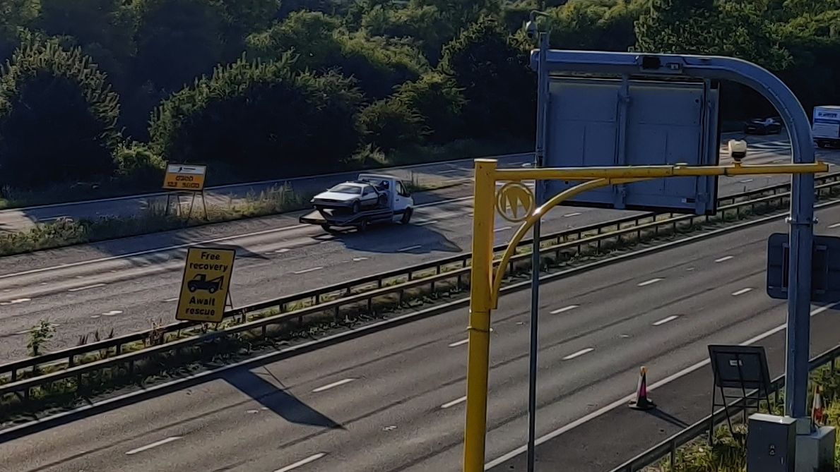 delorean on a flatbed truck going down the m4