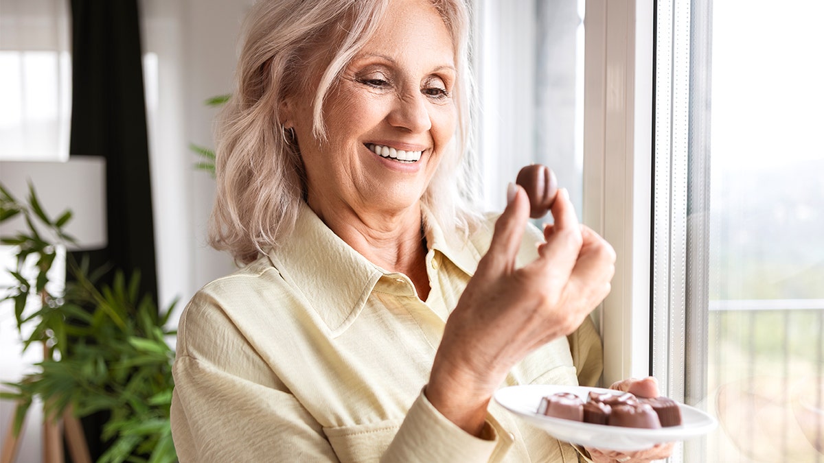 Older woman holding candy bar
