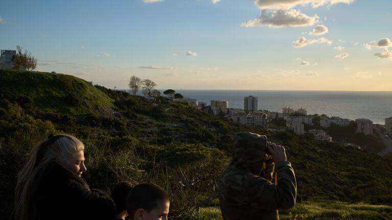 From a lookout, a man uses a binocular looking for the possible arrival of the US Navy's aircraft carrier USS Gerald R. Ford in the Mediterranean Sea near the coast of Haifa, northern Israel, Friday, February 27, 2026.