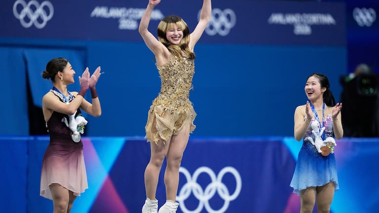 From left to right, silver medalist Kaori Sakamoto of Japan, gold medalist Alysa Liu of the United States, and bronze medalist Ami Nakai of Japan, jump on the podium to receive their medals.