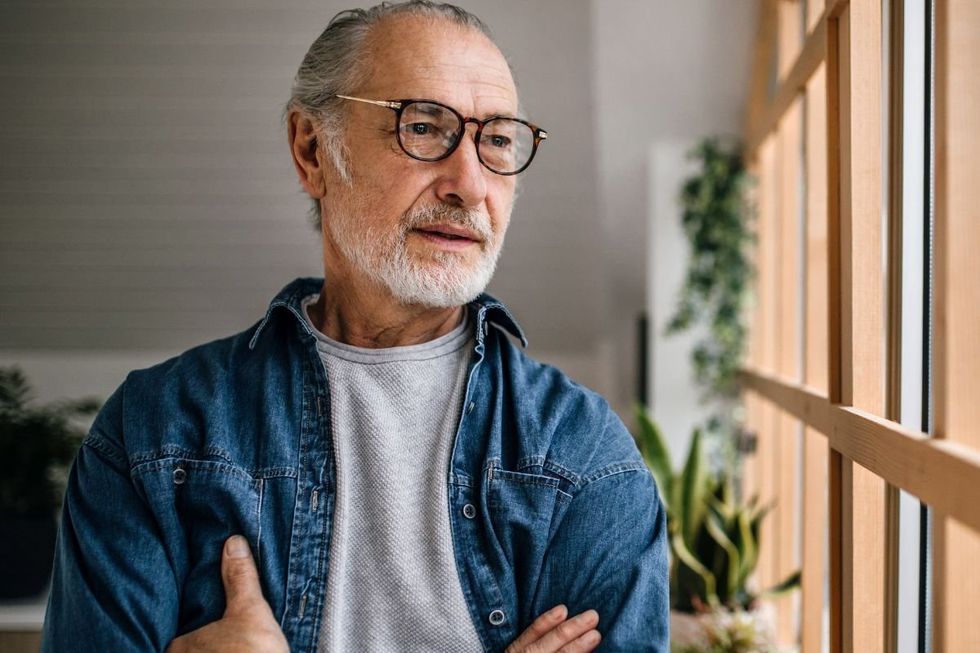 HEALTHY SENIOR MAN LOOKING OUT WINDOW