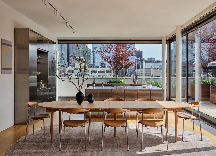Dining room with a large wooden table and views of Manhattan on two sides