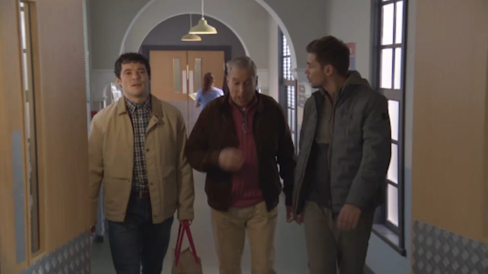 hollyoaks rex froggy ste three individuals walk through a hospital corridor
