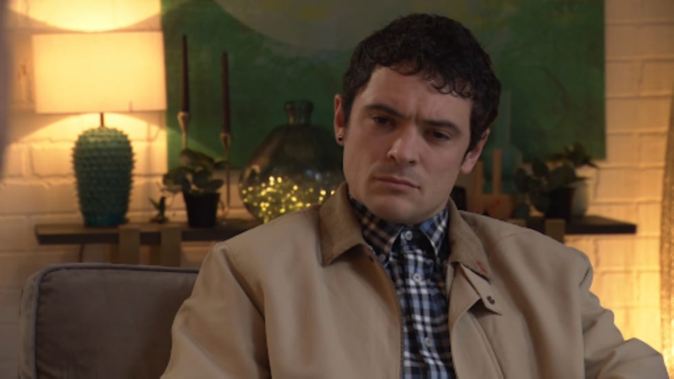 hollyoaks rex gallagher seated person in a living room setting