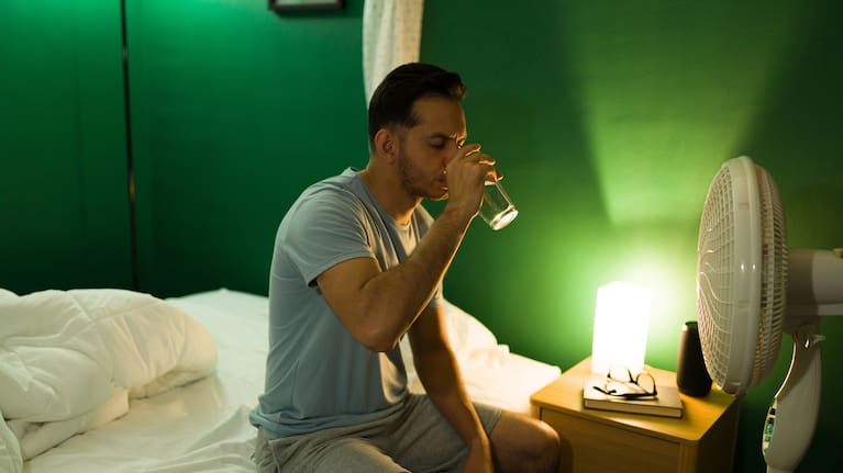 A man drinking from a glass of water with a fan (file image).