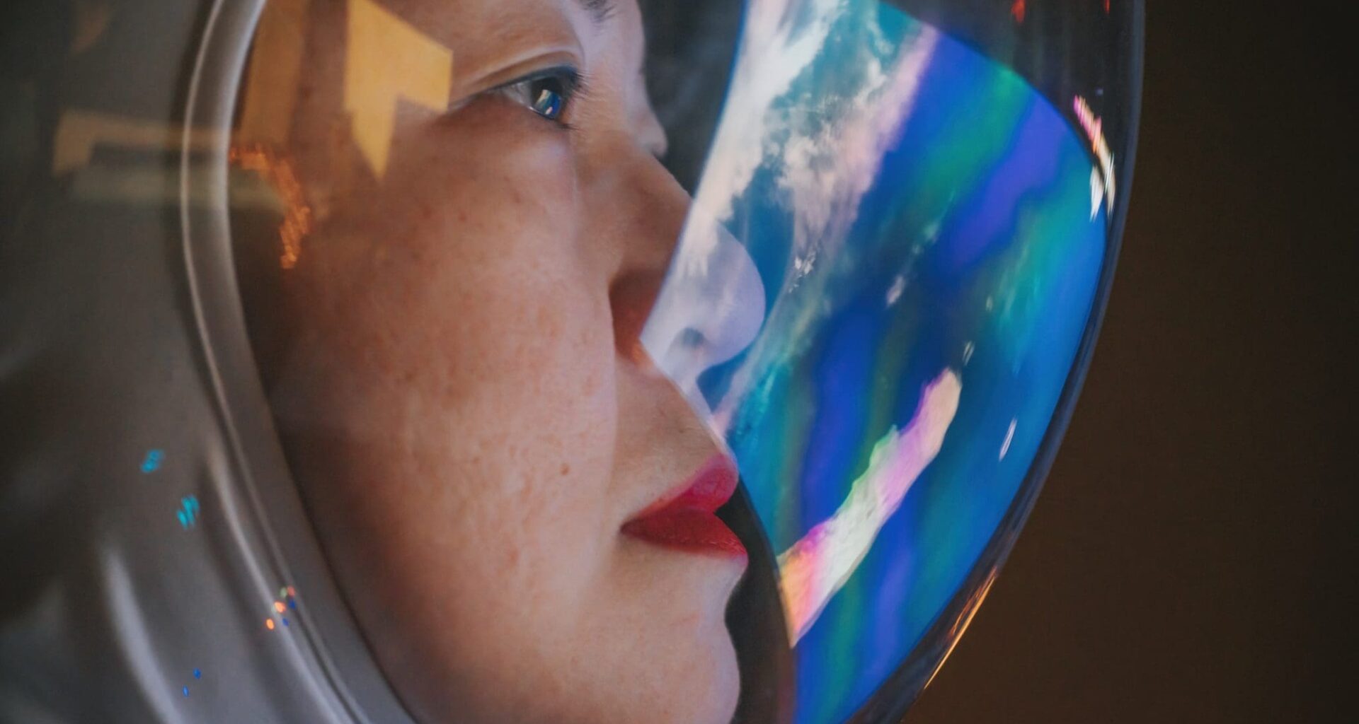 Asian chinese mid adult female astronaut looking at earth through window from spaceship at outer space