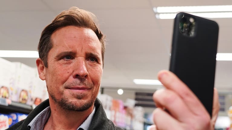 Ian Rosenfeldt, the creator of Made O'Meter mobile app, demonstrates how shoppers can use the application to identify and boycott American goods in a grocery store in Copenhagen.