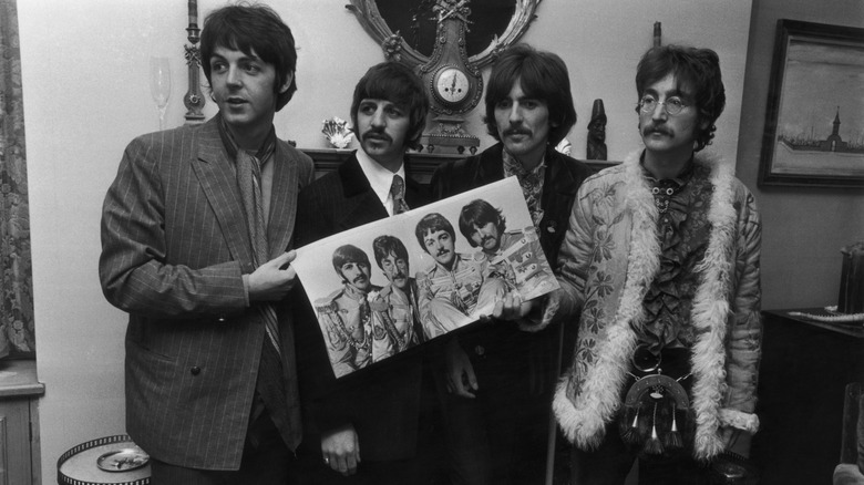 The Beatles posing with Sgt. Peppers record sleeve