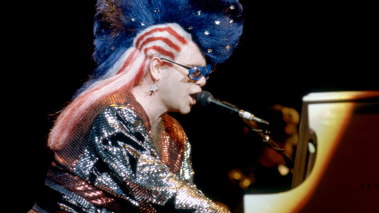 Elton John playing piano and singing in american flag wig