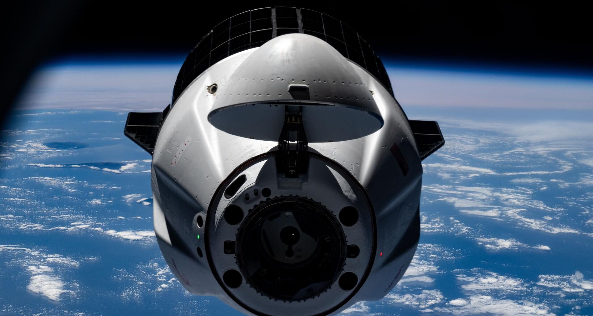A SpaceX Dragon cargo spacecraft with its nosecone open and carrying over 5,000 pounds of science, supplies, and hardware for NASA's SpaceX CRS-33 mission approaches the International Space Station for an automated docking to the Harmony module's forward port. Both spacecraft were flying 261 miles above the Atlantic Ocean south of the Azores, a Portuguese archipelago, at the time of this photograph.