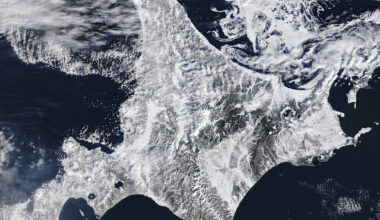 A satellite image shows snow blanketing Hokkaido, Japan, with sea ice swirling just north of the island.