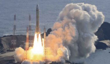 Japan's H3 rocket lifts off from Tanegashima Space Center, flames and smoke rising over the Pacific.
