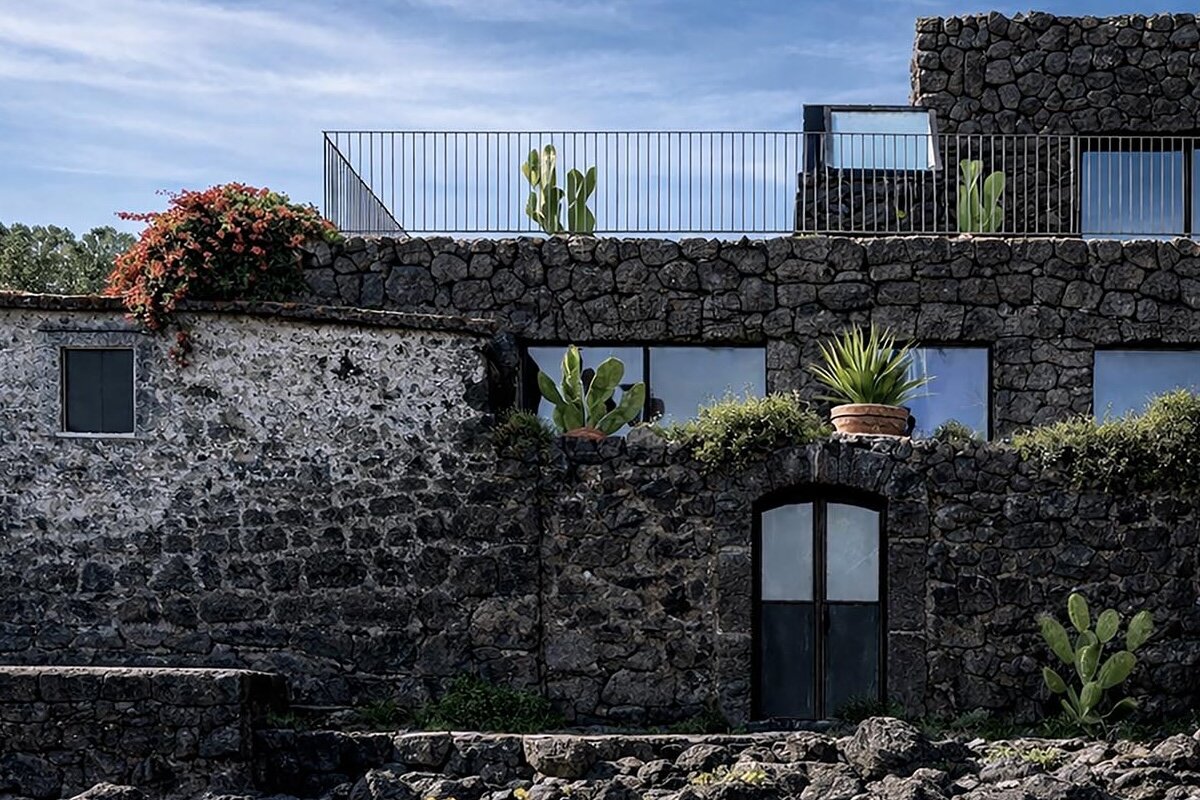 lava stone and fisherman's house merge into villa on sicilian coast
