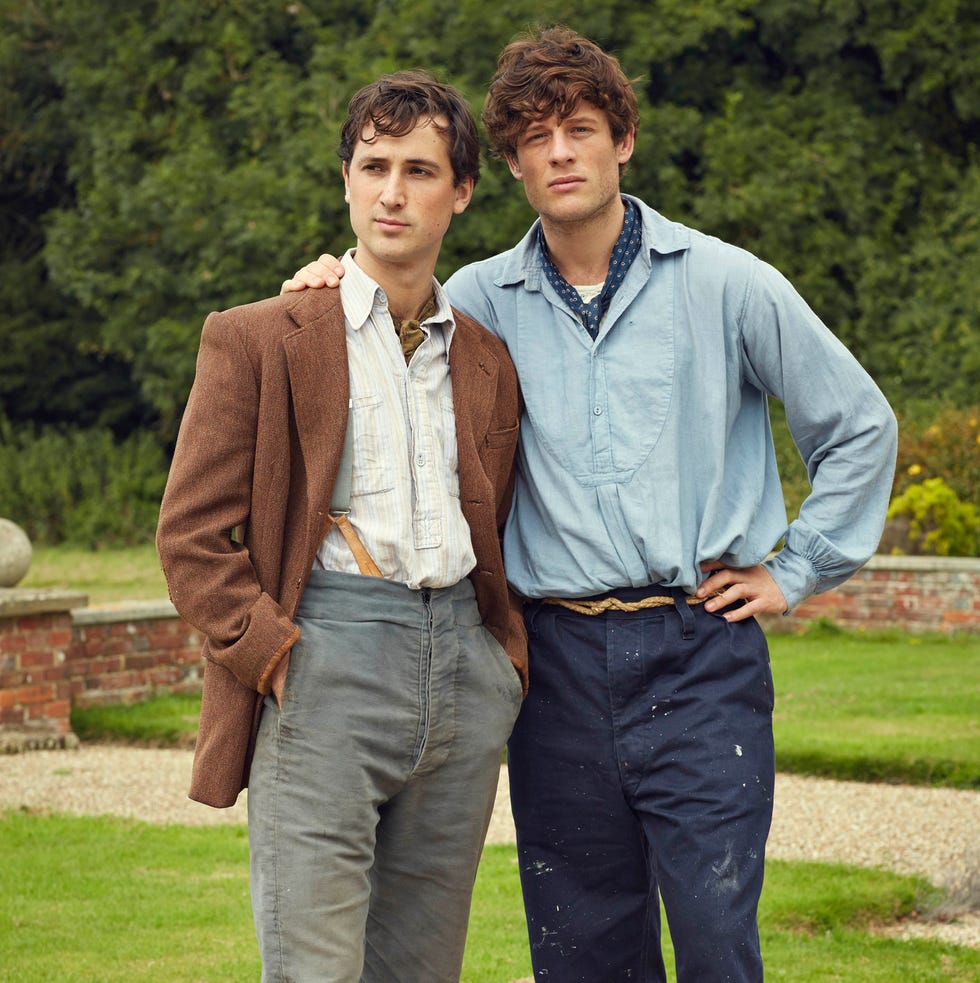 two young men posing together outdoors in casual attire