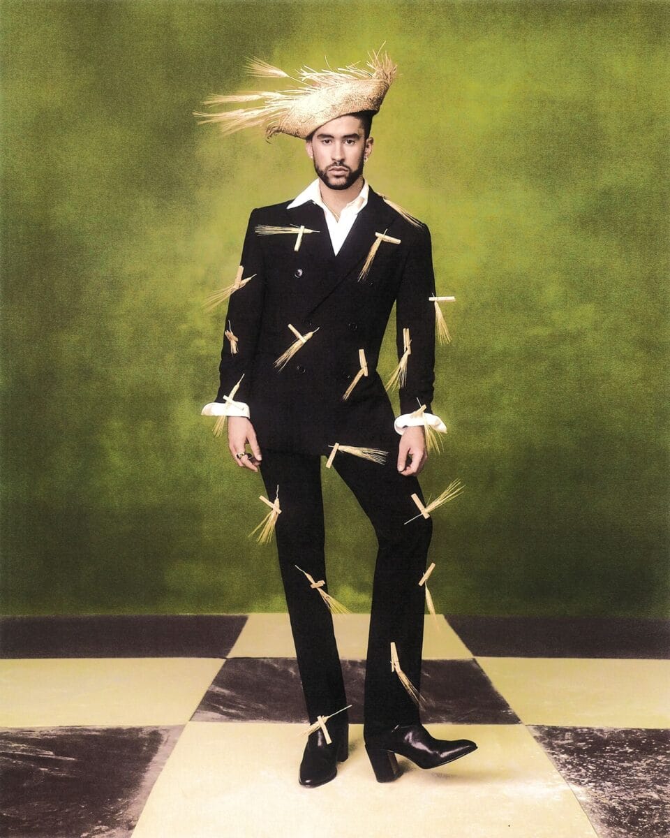 an editorial portrait by Szilveszter Makó of Bad Bunny wearing a a pava and suit covered in dried palm leaves