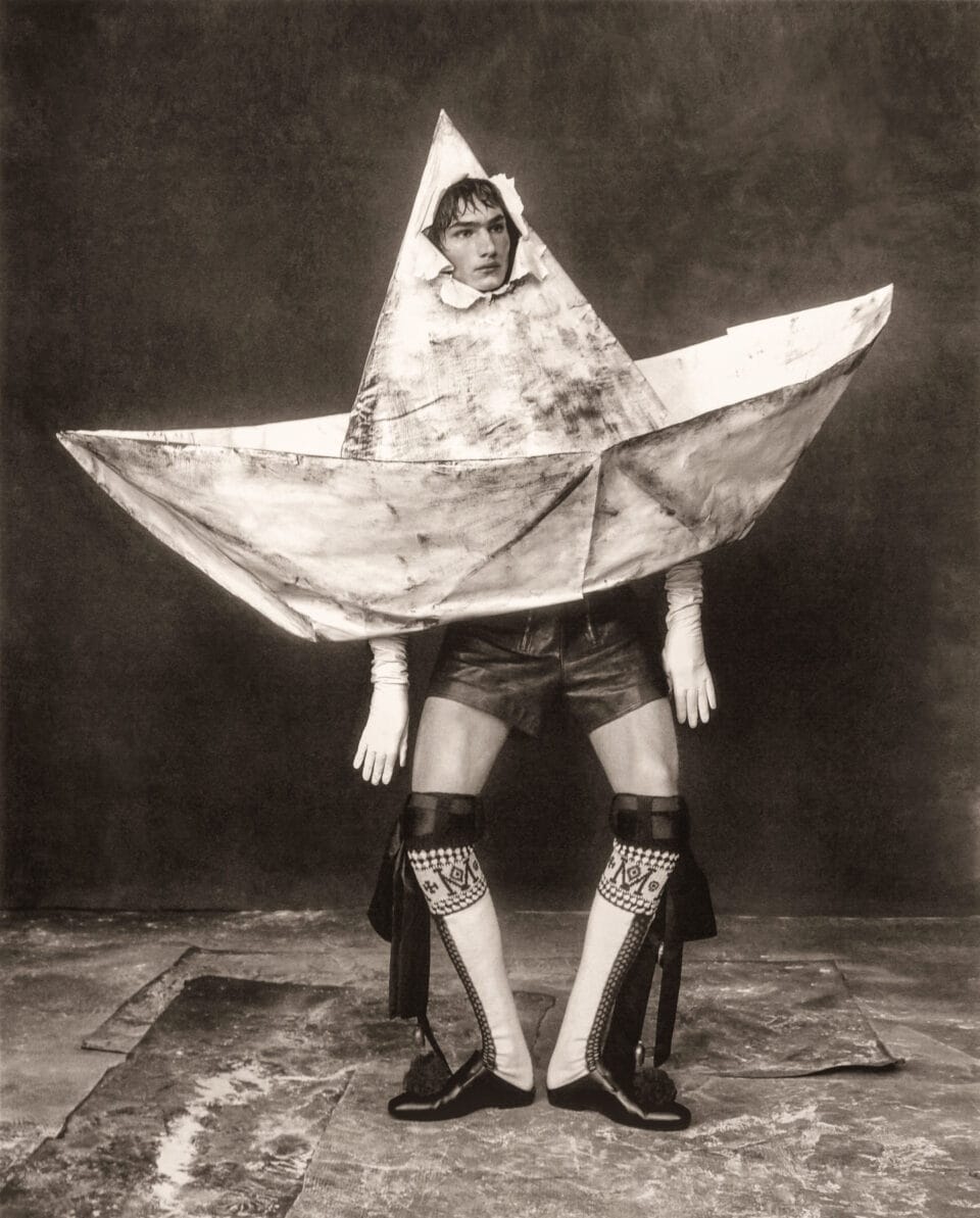 an editorial portrait by Szilveszter Makó of a model in a large garment shaped like a paper hat