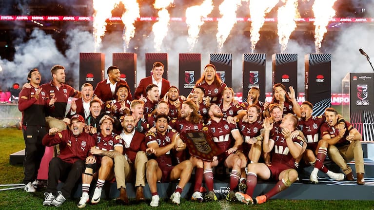 Maroons players celebrate with the shield after victory during the State of Origin game three match between the Queensland Maroons and the New South Wales Blues.
