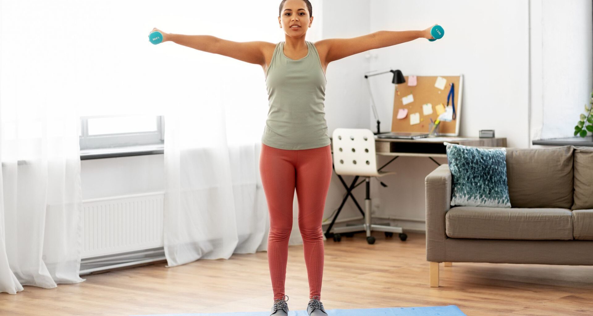 woman does lateral shoulder raise exercise at home