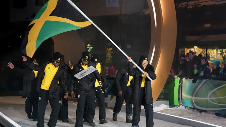 Mica Moore, flag bearer of Jamaica, leads her team in during the Olympic opening ceremony at the 2026 Winter Olympics, in Cortina d'Ampezzo, Italy