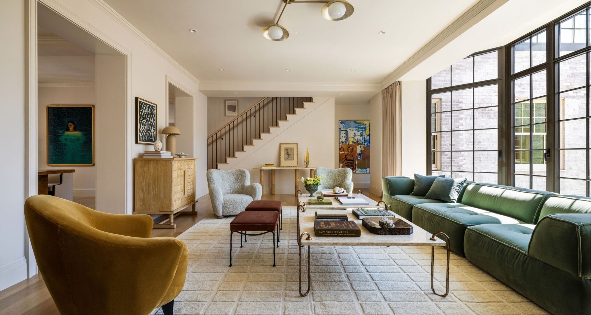 living room with white rug, yellow arm chair and green sofa