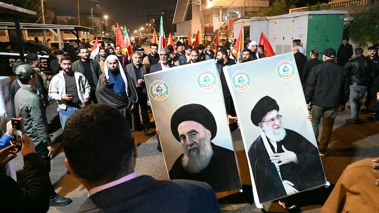 People, carrying posters of Shia cleric Ali al-Sistani and Iranâs Supreme Leader Ali Khamenei, gather in a demonstration in report of the Iranian regime.