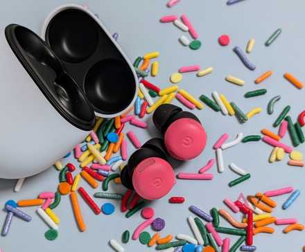 Google Pixel Buds Pro 2 open case with peony buds on table surround by sprinkles