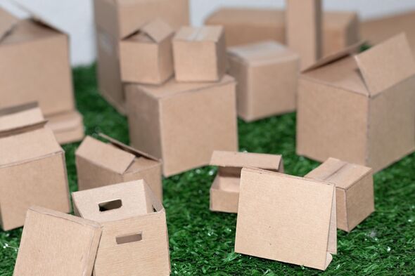 Mini recycled cardboard boxes grouped on green artificial grass