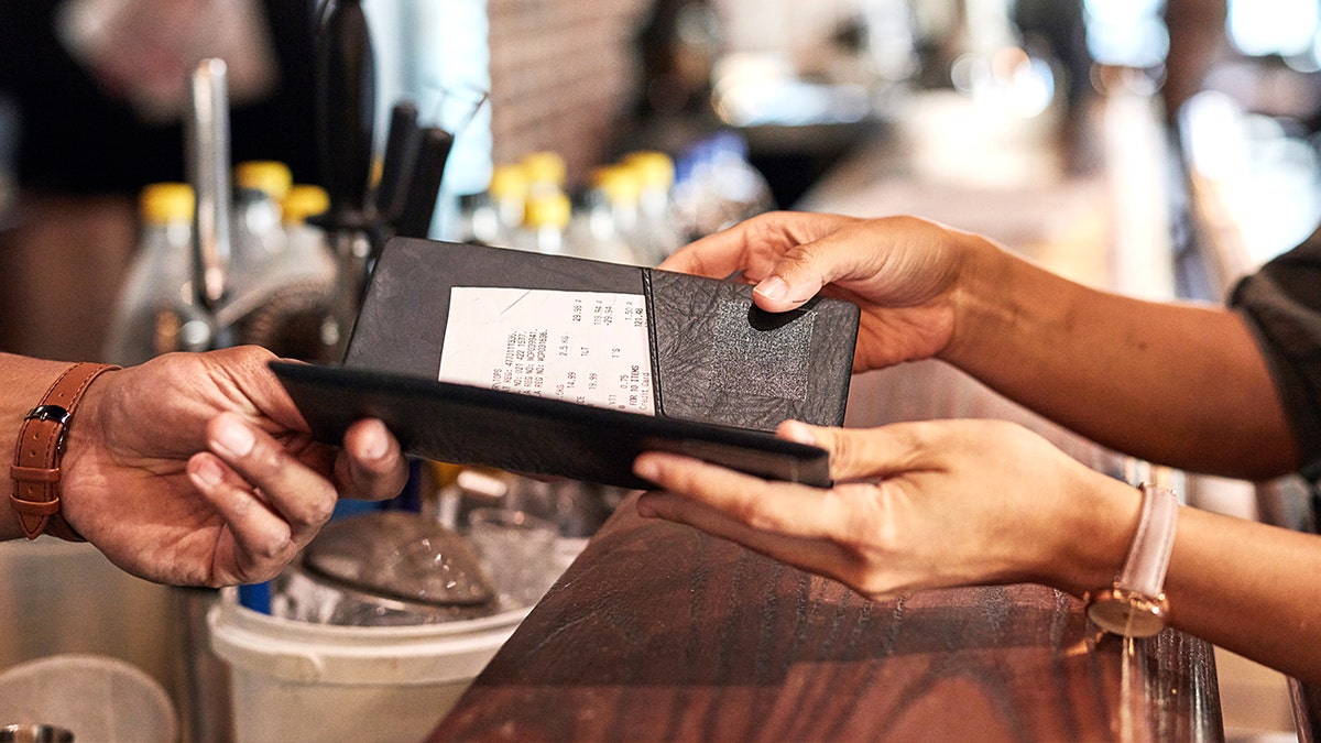 Diner handing check to waiter