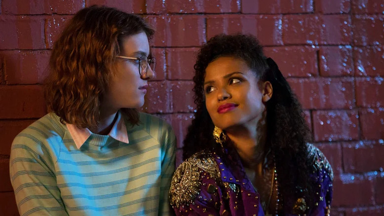 Yorkie and Kelly sitting next to each other in front of brick wall in Black Mirror