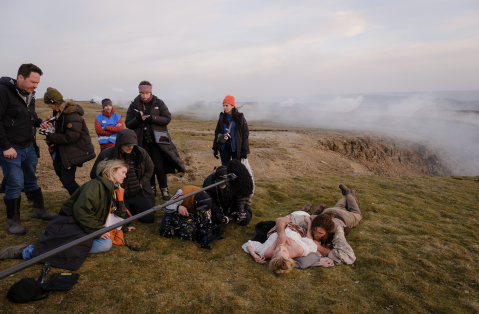 film crew shooting a scene with actors on location