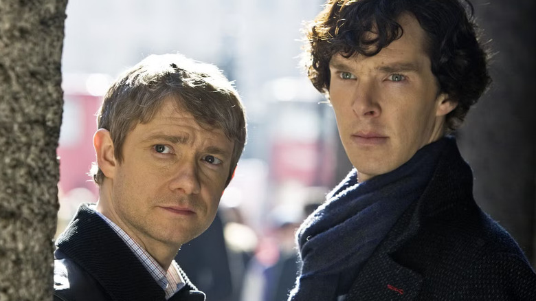 Martin Freeman as John Watson stands next to Benedict Cumberbatch in Sherlock