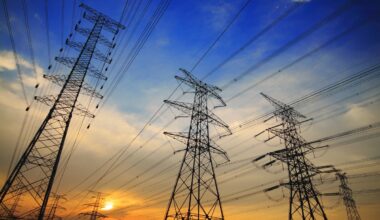 High tension power lines against a sunset