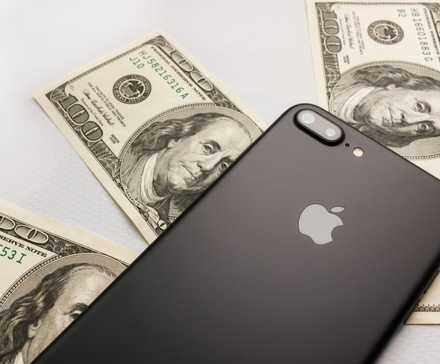 Black iPhone 8s plus on three hundred dollar bills.