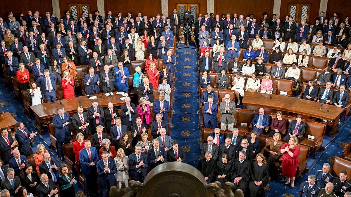 Members of Congress listen and react from the House floor during the president’s annual address to a joint session.