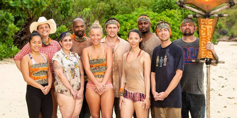 The cast of Survivor David vs. Goliath stand on a beach