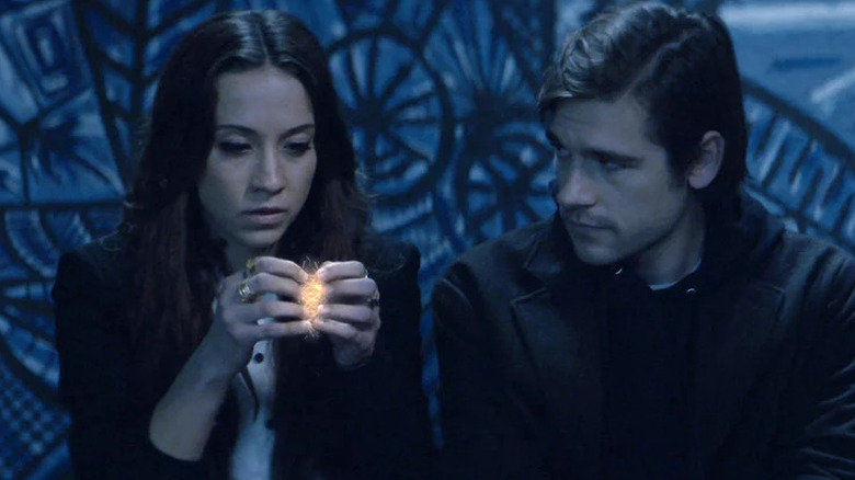 Julia holding glowing magical object next to Quentin in The Magicians