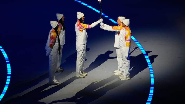 The Olympic torch is passed during the Olympic opening ceremony at the 2026 Winter Olympics, in Milan, Italy