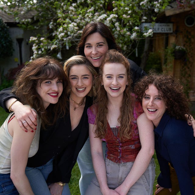 group of five individuals posing together outdoors group of five individuals posing together outdoors