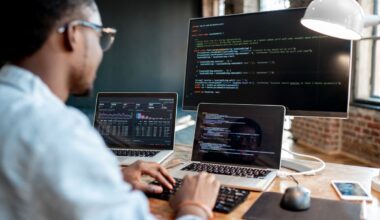 A computer programmer writes code with a laptop.