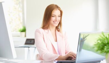 Professional working on a laptop while smiling.