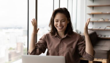 An investor cheers behind a laptop.