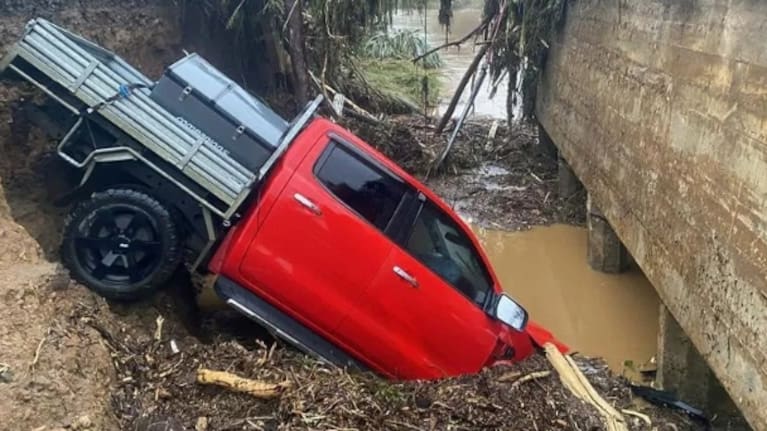 Ute partially submerged in floodwaters near bridge on SH39.